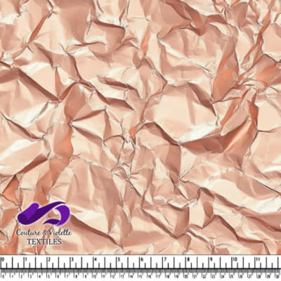 Crumpled shiny metallic rose gold fabric texture